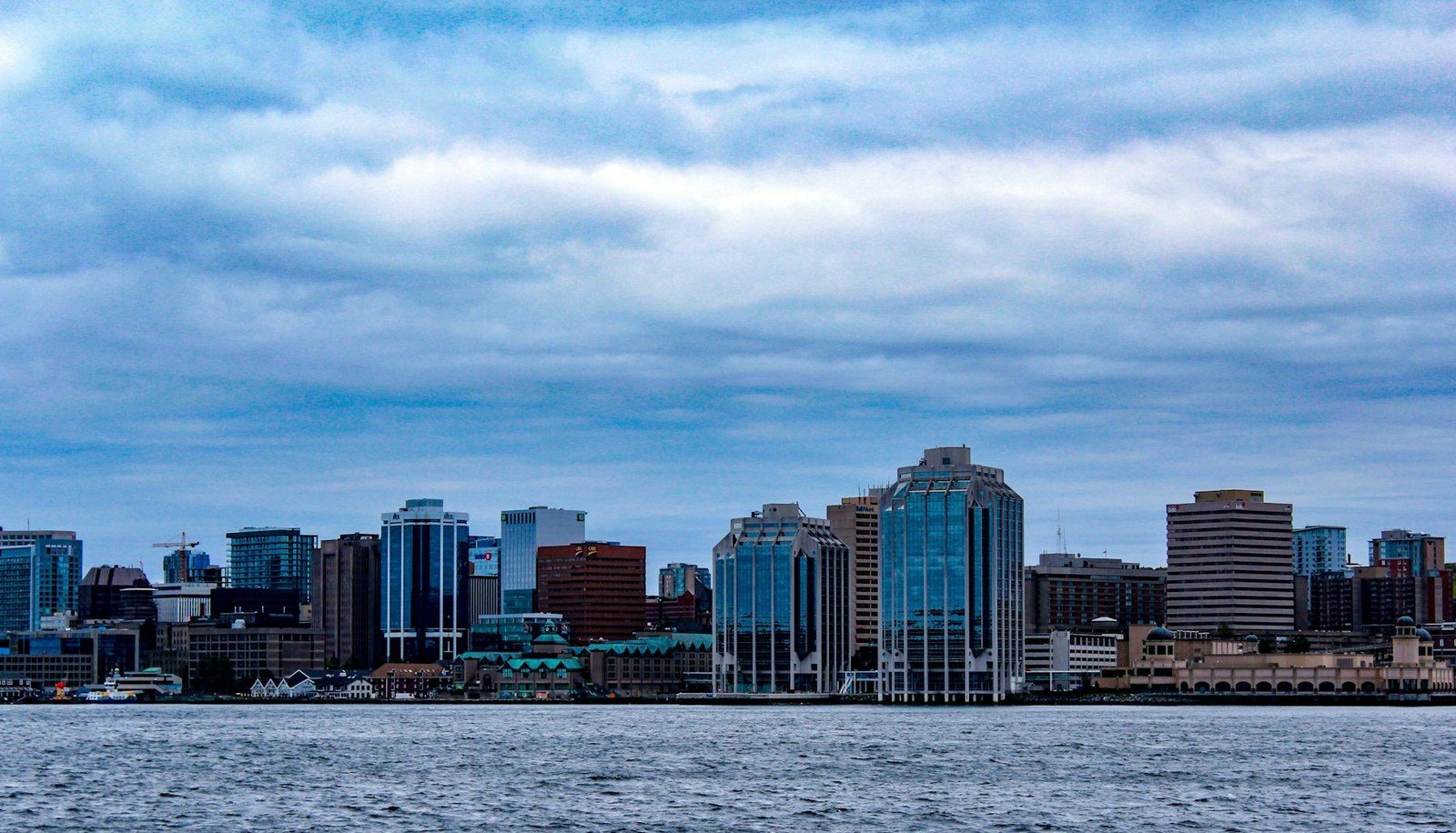 Le centre-ville d’Halifax vu de l’autre côté du port, sous un vaste ciel nuageux