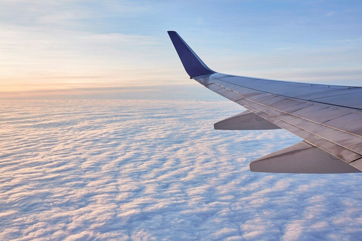 L’aile d’un avion de ligne au-dessus de nuages d’un blanc éclatant, vue d’un siège côté hublot